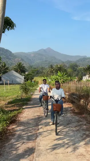 Bersepeda berdua di jalan setapak tepi sawah