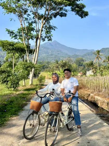 Berpose dengan sepeda di bawah pepohonan