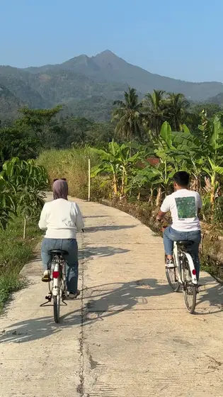 Dilla dan Nofan bersepeda beriringan menuju pegunungan