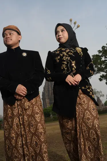 Berdiri berdampingan dalam beskap dan kebaya hitam