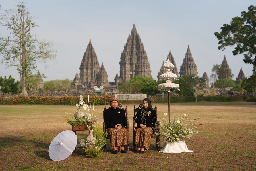 Dilla dan Nofan duduk berdampingan di depan Candi Prambanan