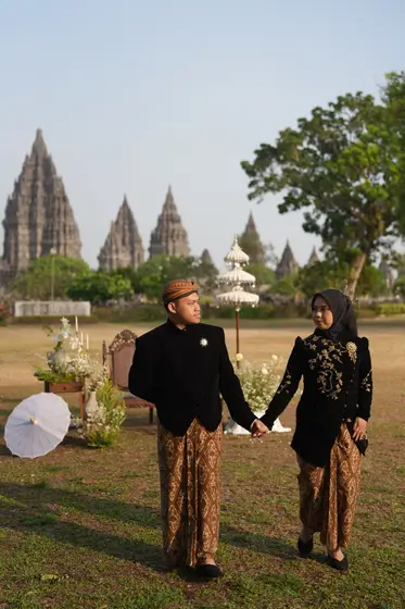 Berjalan bergandengan dengan latar Candi Prambanan