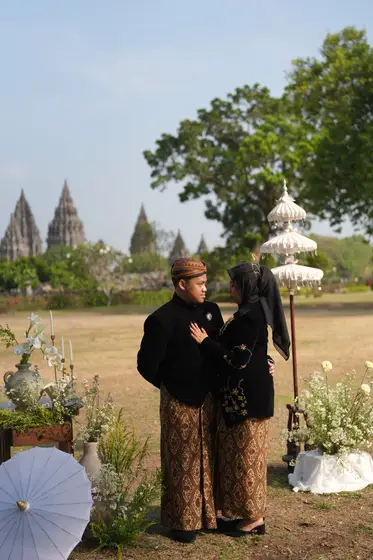 Berdiri berdekatan di antara rangkaian bunga Prambanan