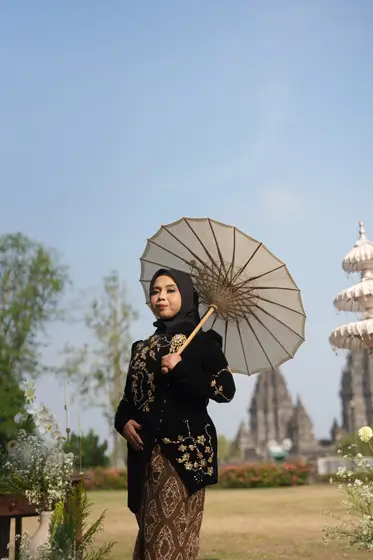 Dilla membawa payung kertas di Prambanan