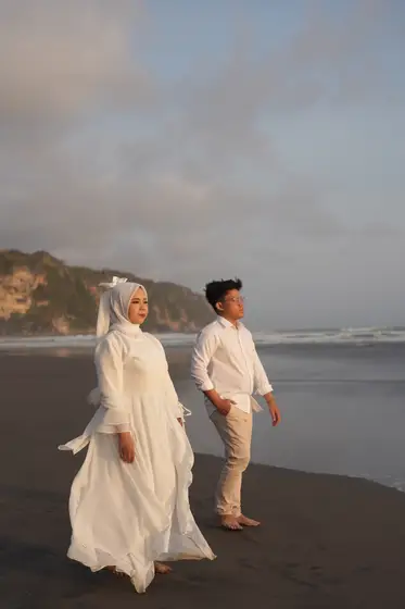 Berjalan di tepi pantai dengan tebing di belakang